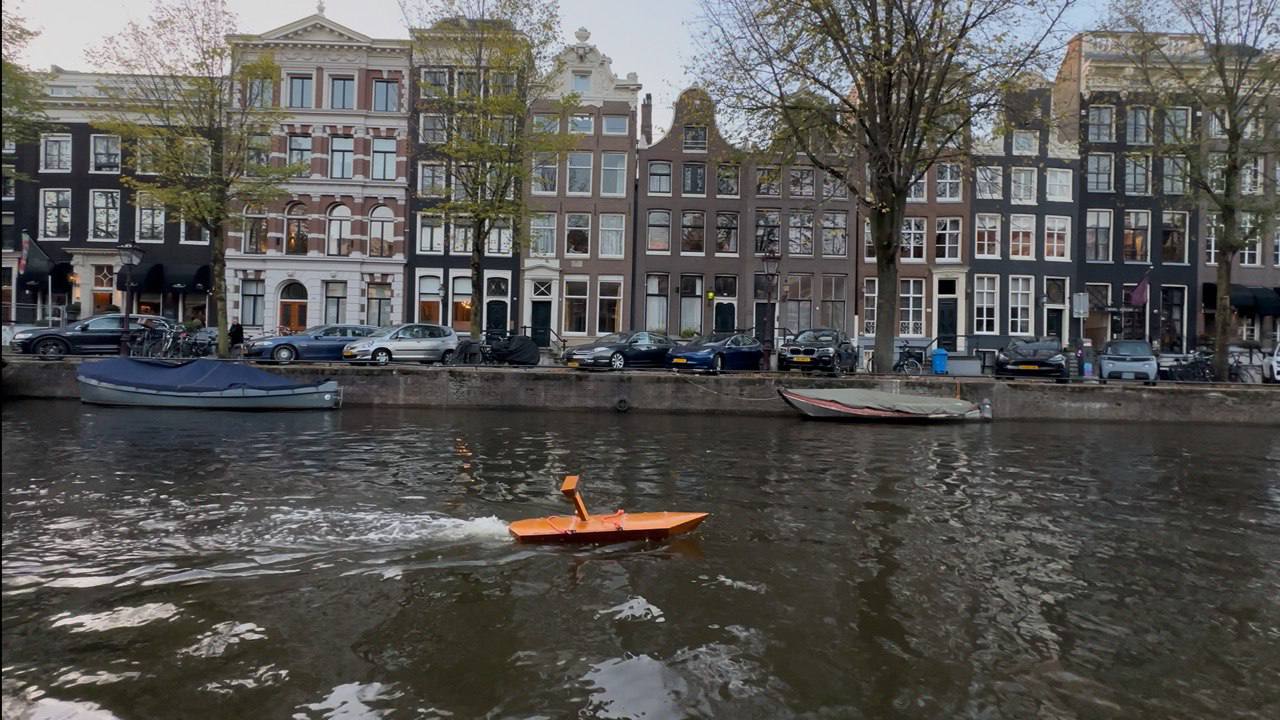 WaterWatch's orange autonomous monitoring boat on an Amsterdam canal